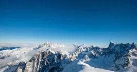 Les sommets enneigés des Alpes sous un ciel bleu