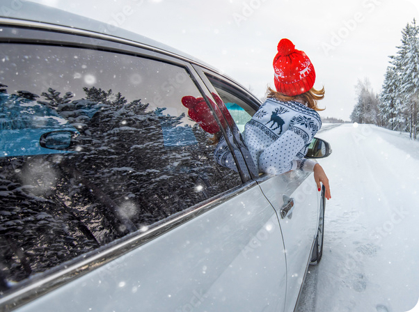 Woman with head out of car in the snow on a transfer