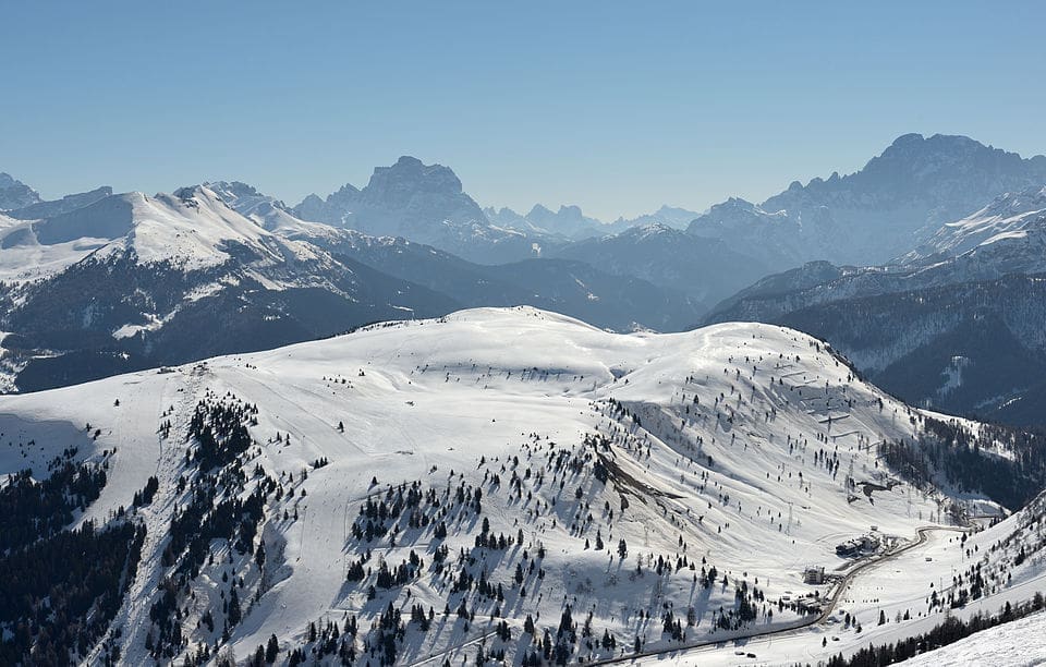 Skiers on the Cherz area in Alta Badia with the Dolomites and Passo Campolongo in the background