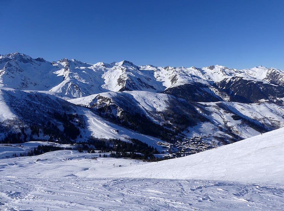 The snowy slopes of Valmorel ski resort with the Lauzière mountain range in the background